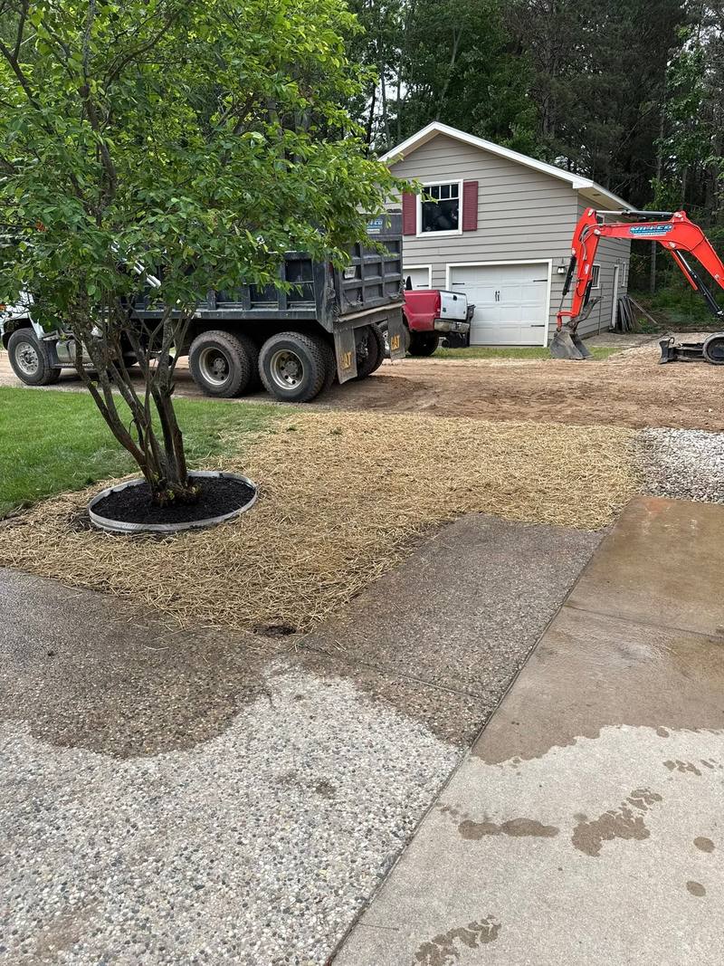 Finished drain area with gravel beside a driveway