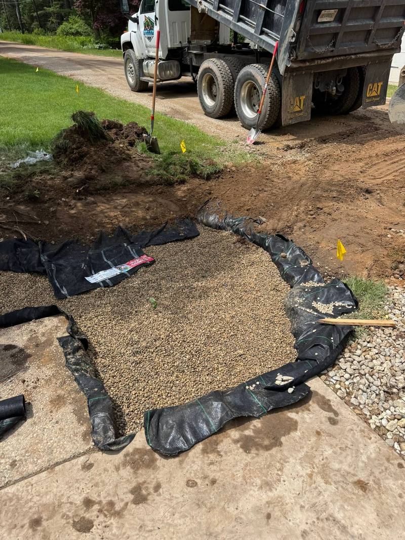 Drain pit filled with pea stone before the top layer of fabric