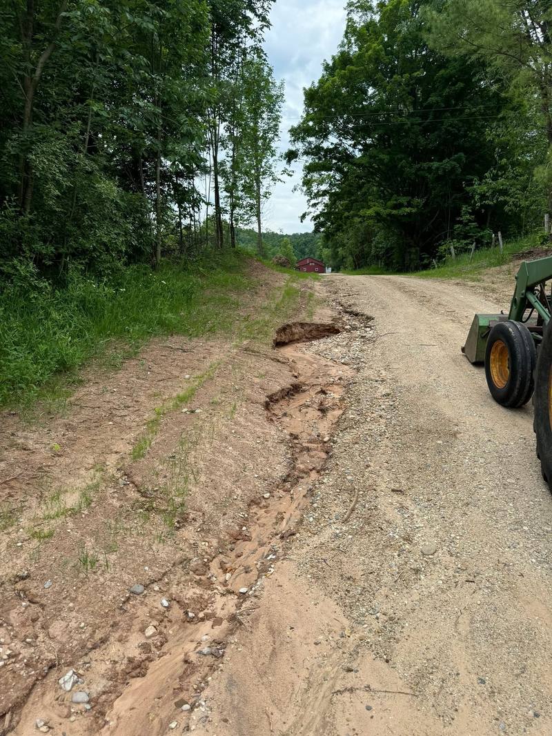 Eroded driveway being regraded with a tractor