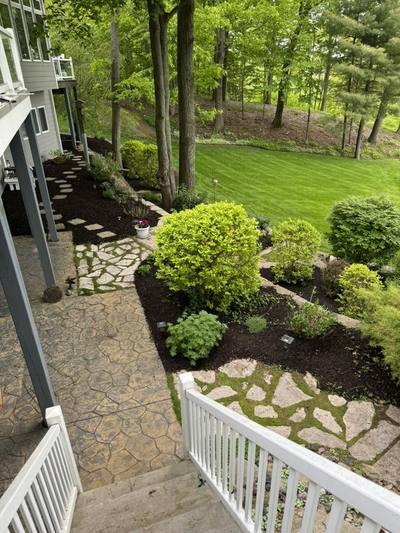 Terraced beds with round shrubs beside a flagstone path and stairs